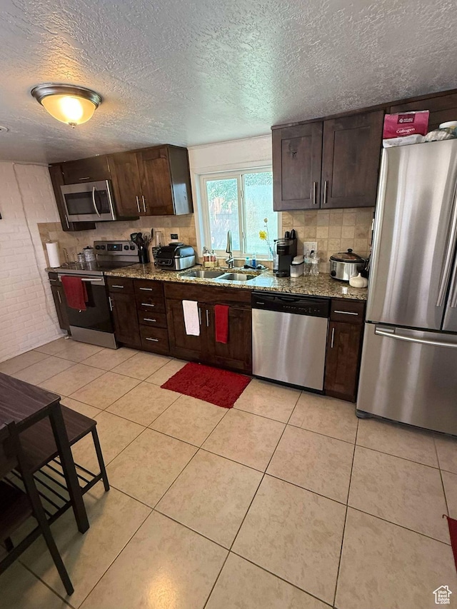 3274 W 3100 S, West Valley City, UT 84119 - kitchen featuring a textured ceiling, a sink, dark brown cabinetry, backsplash, and stainless steel appliances
