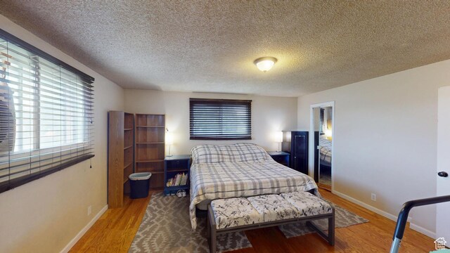983 E Antelope Dr N, Layton, UT 84040 - bedroom featuring wood finished floors, multiple windows, and a textured ceiling