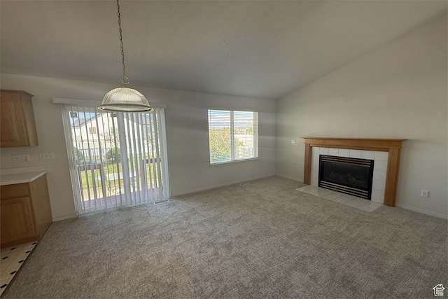 166 E Cove Rd, Saratoga Springs, UT 84045 - unfurnished living room with lofted ceiling, a tiled fireplace, light colored carpet, and baseboards