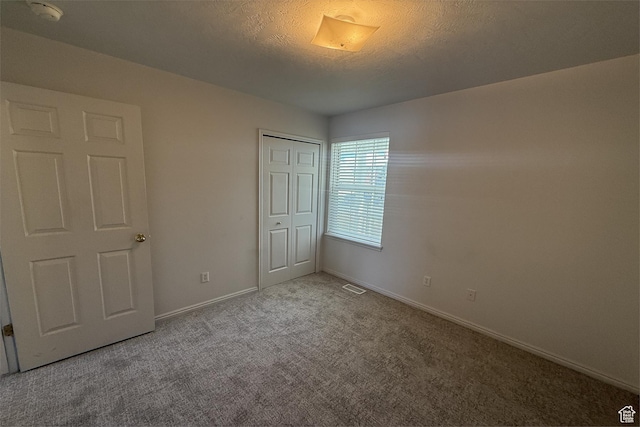 166 E Cove Rd, Saratoga Springs, UT 84045 - unfurnished bedroom with carpet flooring, baseboards, a closet, and a textured ceiling