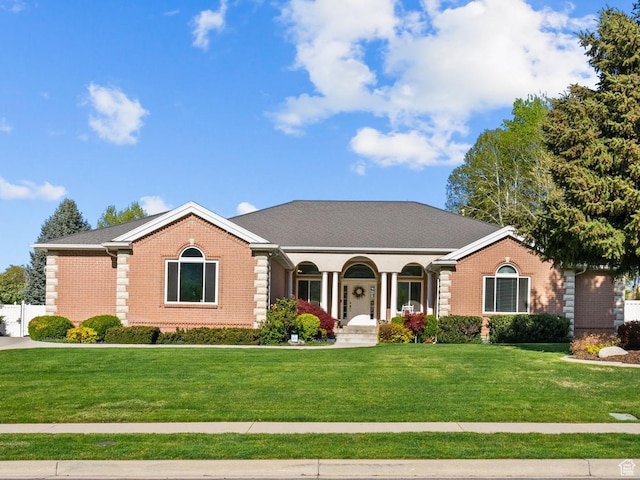 ranch-style house featuring brick siding and a front yard