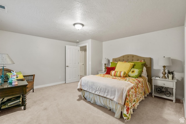bedroom with baseboards, light carpet, visible vents, and a textured ceiling