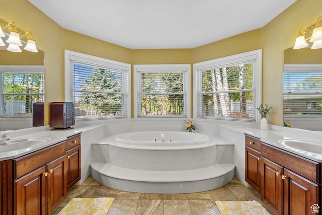 bathroom featuring a garden tub, two vanities, and a sink