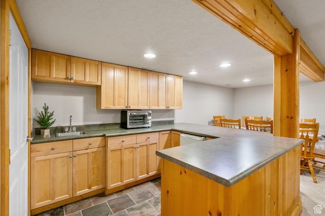 kitchen with a peninsula, white dishwasher, a sink, a toaster, and recessed lighting