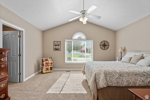 bedroom with light colored carpet, vaulted ceiling, baseboards, and a ceiling fan