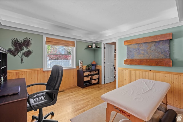 office area featuring wooden walls, wainscoting, and wood finished floors