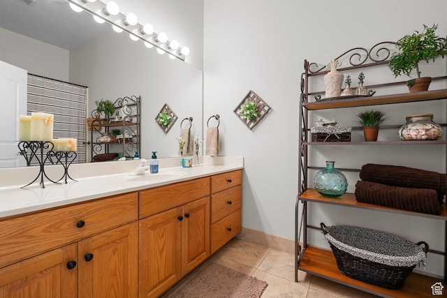 bathroom featuring baseboards, tile patterned flooring, and vanity