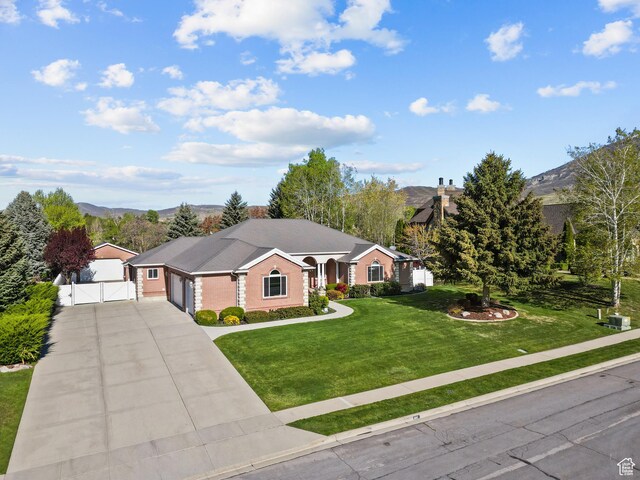 ranch-style home featuring fence, a garage, concrete driveway, a front lawn, and a gate