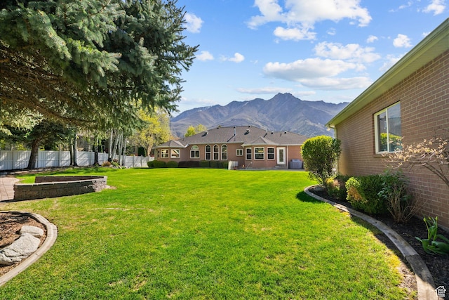 view of yard featuring a mountain view and fence