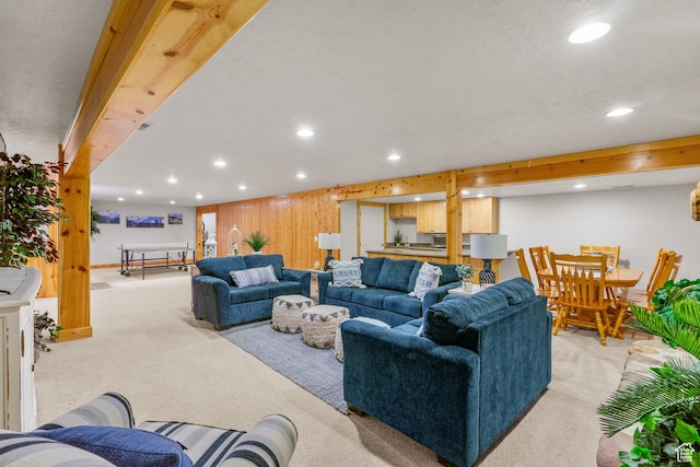 living room with light colored carpet, wood walls, and recessed lighting