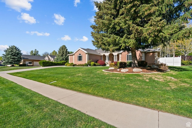 ranch-style home featuring a front yard and fence