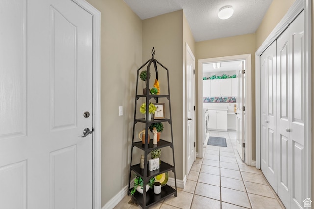 interior space featuring a textured ceiling, baseboards, and light tile patterned floors