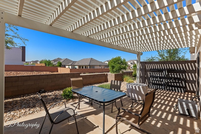 view of patio / terrace featuring a fenced backyard, a pergola, outdoor dining space, and a residential view