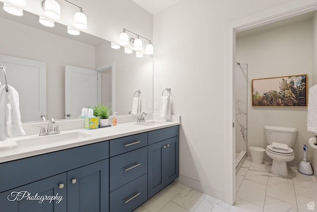 bathroom with a sink, double vanity, toilet, and marble finish floor
