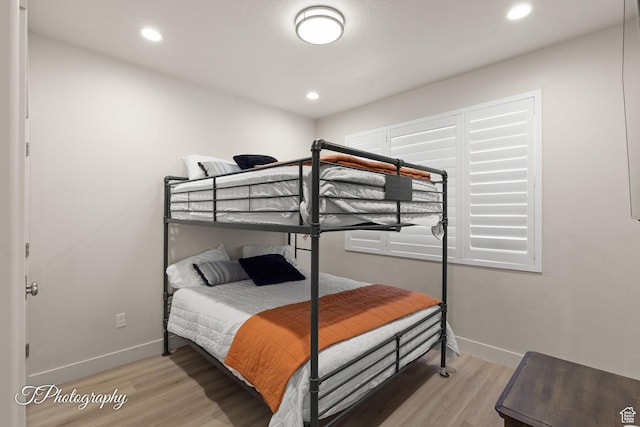 bedroom with baseboards, light wood finished floors, and recessed lighting