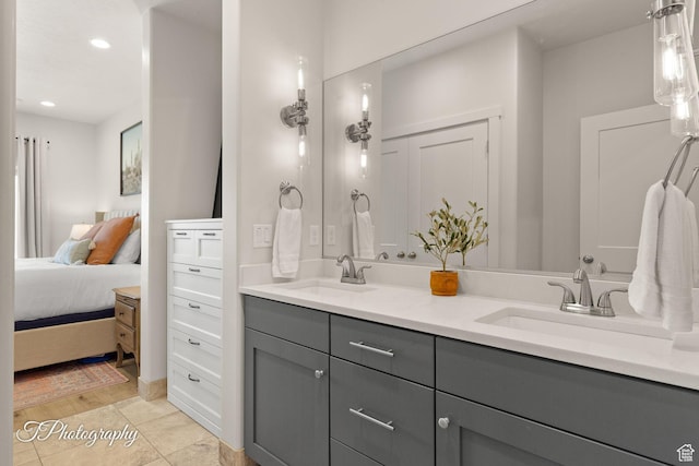 full bath featuring a sink, double vanity, ensuite bathroom, and recessed lighting