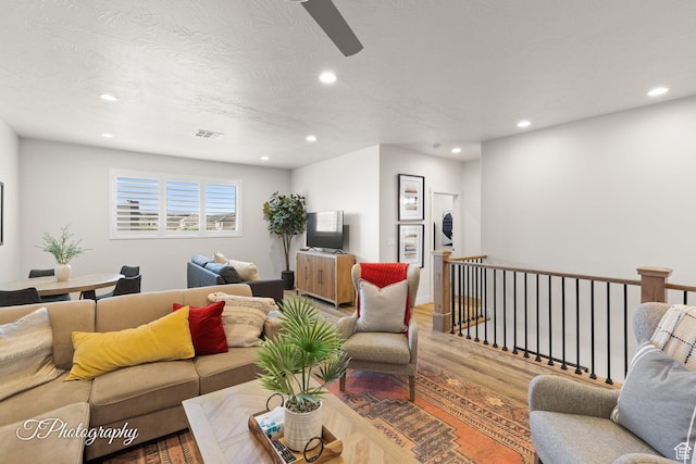 living area featuring ceiling fan, recessed lighting, visible vents, and light wood-style floors