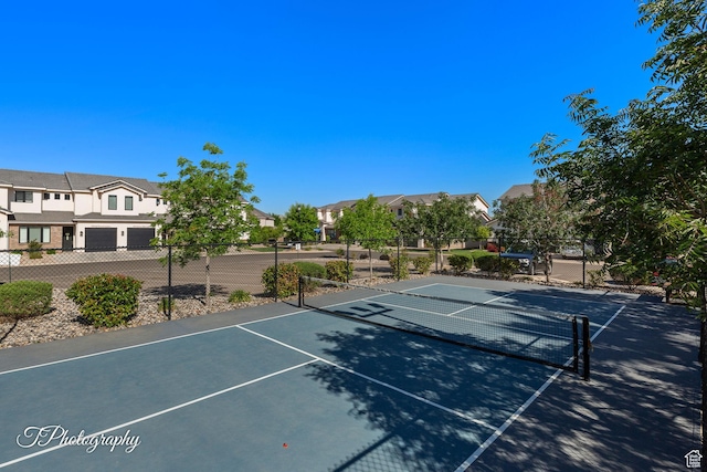 view of sport court featuring a residential view and fence