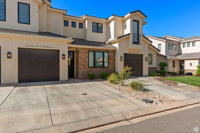 townhome / multi-family property featuring concrete driveway, stucco siding, and an attached garage