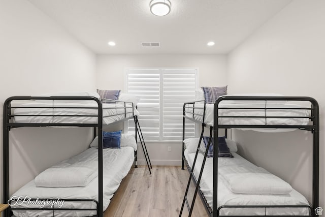 bedroom with baseboards, recessed lighting, visible vents, and wood finished floors