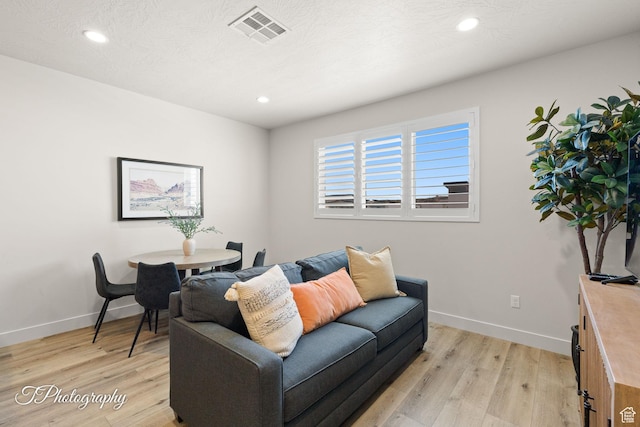 living area with light wood-type flooring, recessed lighting, baseboards, and visible vents