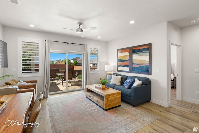 living area featuring light wood finished floors, a ceiling fan, and recessed lighting