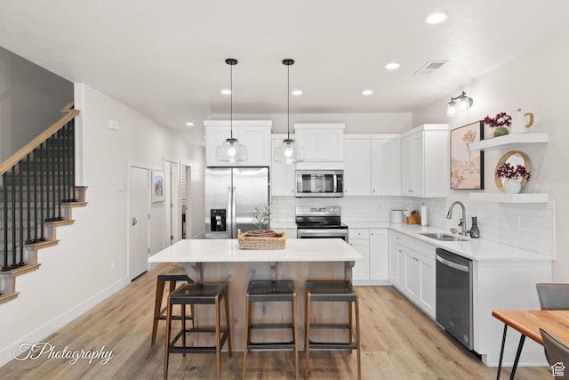 kitchen with a sink, open shelves, decorative backsplash, stainless steel appliances, and white cabinets