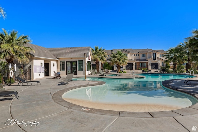 pool with fence and a patio area