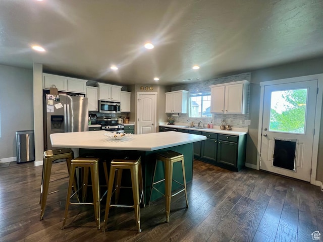 642 W Mulberry St, Stansbury Park, UT 84074 - kitchen with a center island, baseboards, dark wood finished floors, backsplash, and appliances with stainless steel finishes