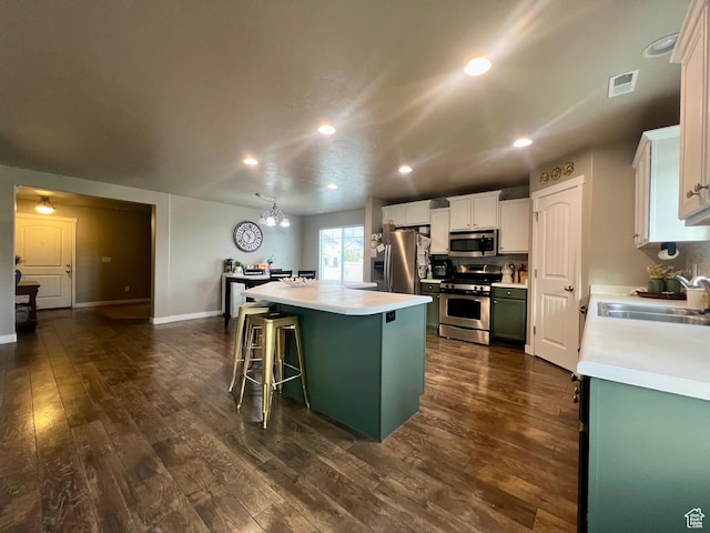 642 W Mulberry St, Stansbury Park, UT 84074 - kitchen featuring a center island, a breakfast bar, a sink, stainless steel appliances, and light countertops