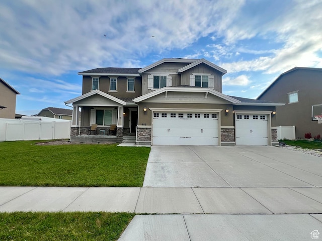 642 W Mulberry St, Stansbury Park, UT 84074 - craftsman inspired home featuring stone siding, covered porch, fence, and a front lawn