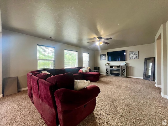642 W Mulberry St, Stansbury Park, UT 84074 - carpeted living room featuring visible vents, baseboards, a ceiling fan, and a fireplace