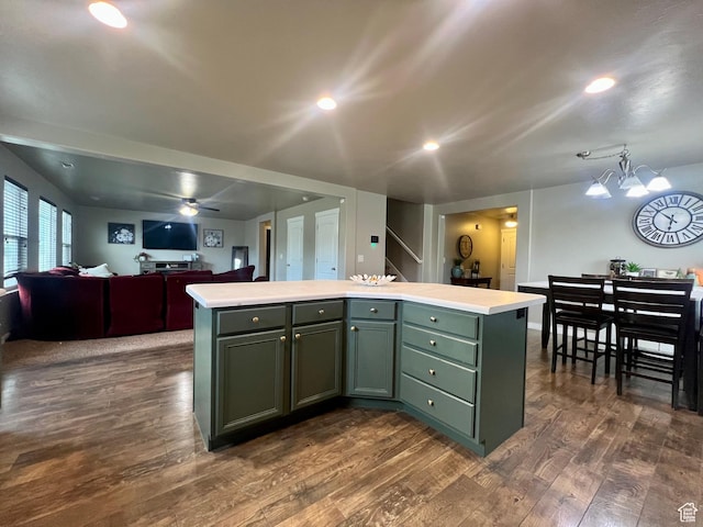 642 W Mulberry St, Stansbury Park, UT 84074 - kitchen with green cabinetry, light countertops, dark wood-style floors, and a kitchen island