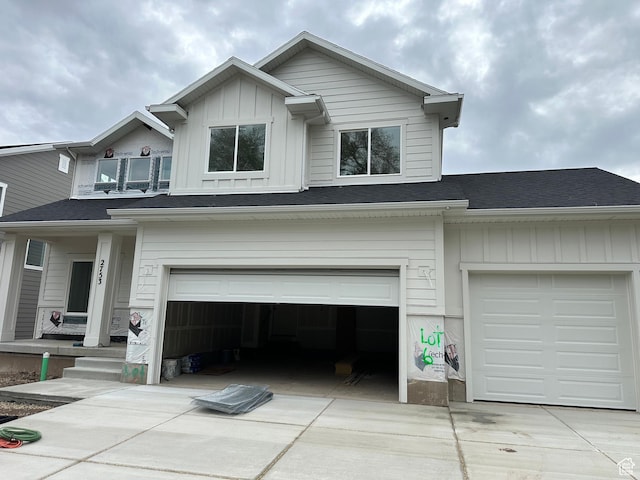view of front facade with driveway, a shingled roof, a garage, and board and batten siding