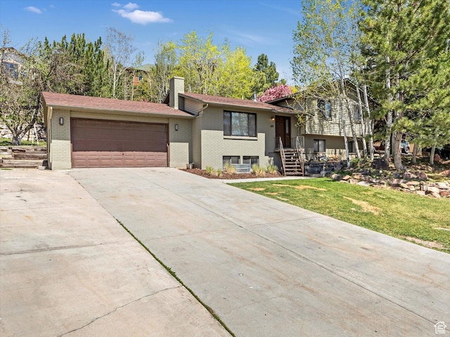 601 E Valley Dr, Heber City, UT 84032 - split level home featuring a chimney, driveway, brick siding, an attached garage, and a front yard