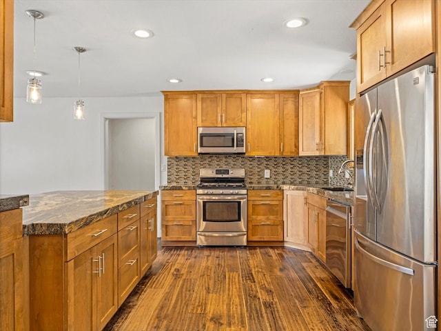 601 E Valley Dr, Heber City, UT 84032 - kitchen featuring dark wood finished floors, a sink, dark stone counters, tasteful backsplash, and appliances with stainless steel finishes
