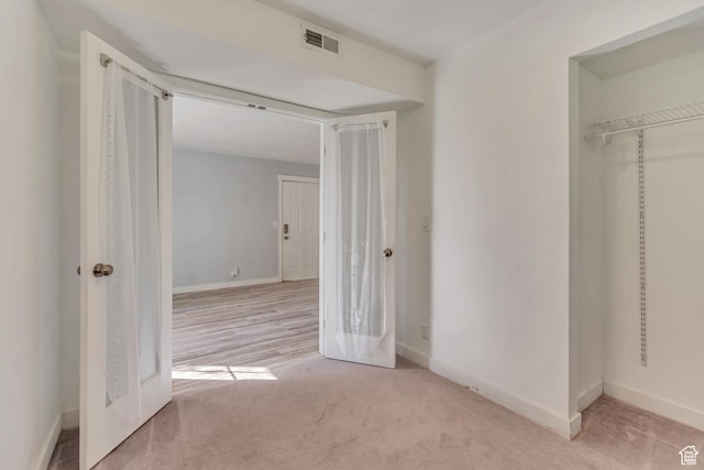 unfurnished bedroom with carpet flooring, a closet, visible vents, and baseboards