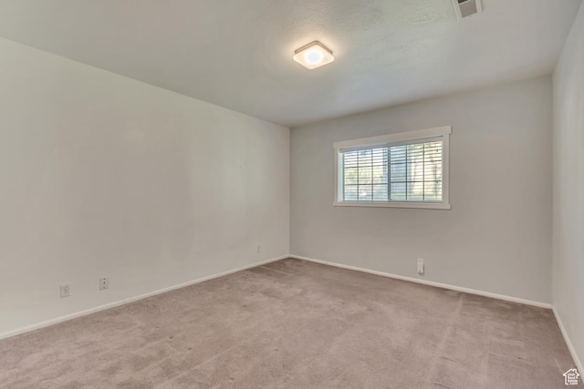 carpeted empty room with baseboards and visible vents