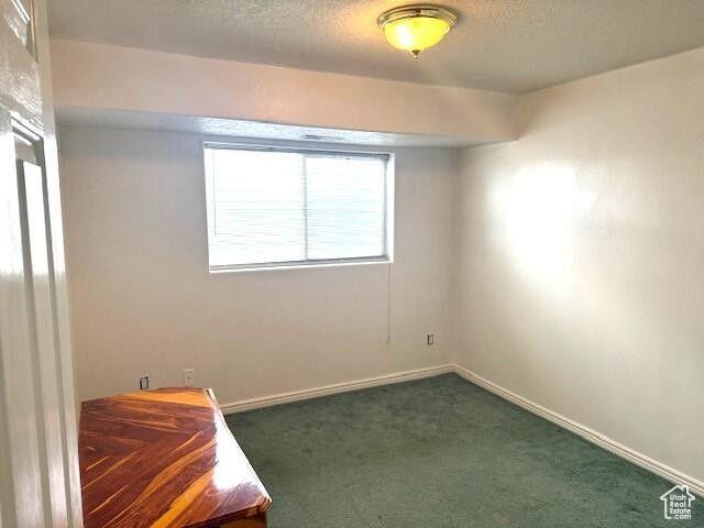 290 W 300 N, Beaver, UT 84713 - unfurnished bedroom with dark colored carpet, baseboards, and a textured ceiling