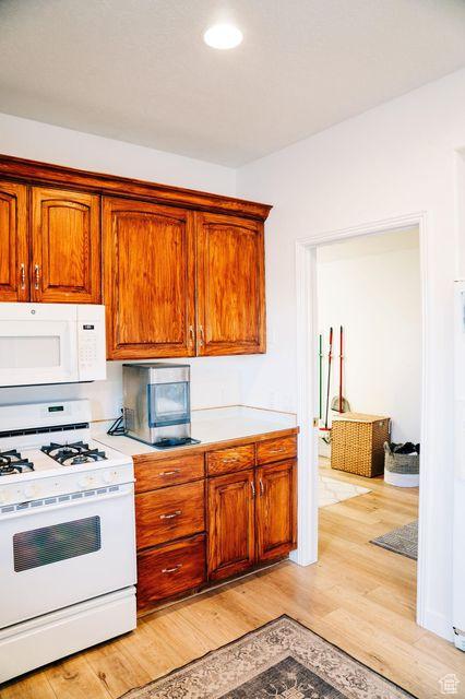 290 W 300 N, Beaver, UT 84713 - kitchen with white appliances, light wood finished floors, light countertops, brown cabinetry, and recessed lighting