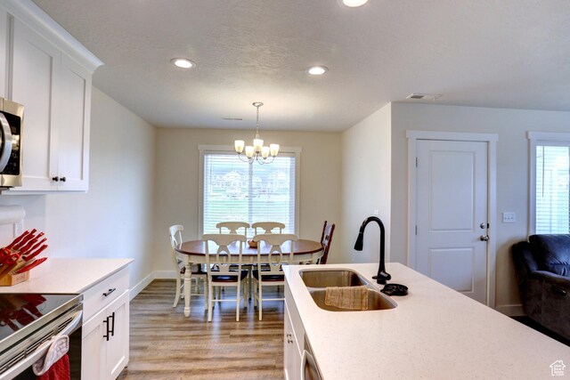 92 E 1040 N, Santaquin, UT 84655 - kitchen featuring a sink, stainless steel appliances, visible vents, light wood-style flooring, and a notable chandelier