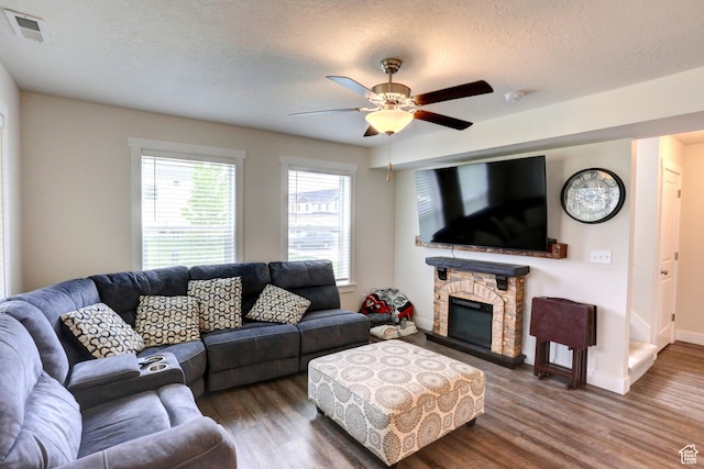 92 E 1040 N, Santaquin, UT 84655 - living room featuring wood finished floors, a ceiling fan, a fireplace, a textured ceiling, and visible vents
