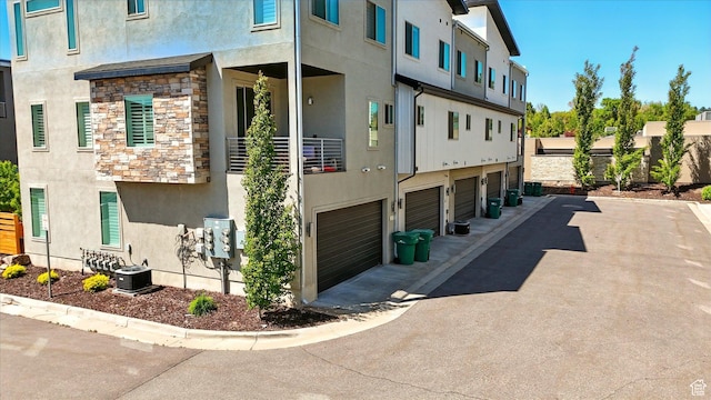 2237 N 450 W, Layton, UT 84041 - view of side of property featuring central AC, stone siding, stucco siding, and a garage