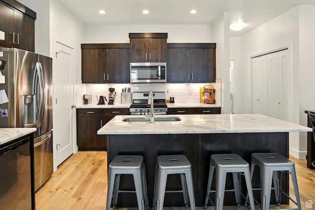 2237 N 450 W, Layton, UT 84041 - kitchen featuring a sink, a kitchen breakfast bar, light wood-style flooring, and appliances with stainless steel finishes