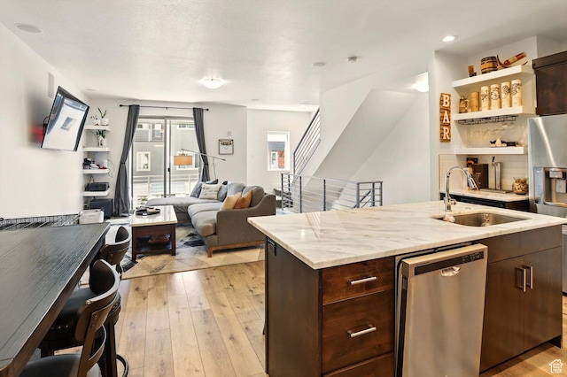 2237 N 450 W, Layton, UT 84041 - kitchen featuring dark brown cabinets, a sink, stainless steel appliances, a center island with sink, and light wood-style floors