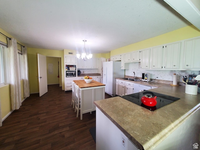 350 N 3rd St, Montpelier, ID 83254 - kitchen featuring white appliances, a chandelier, dark wood finished floors, white cabinets, and a center island