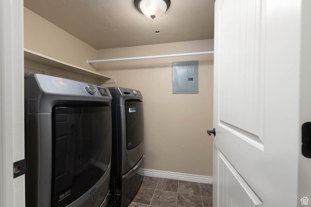 clothes washing area with electric panel, laundry area, separate washer and dryer, and baseboards