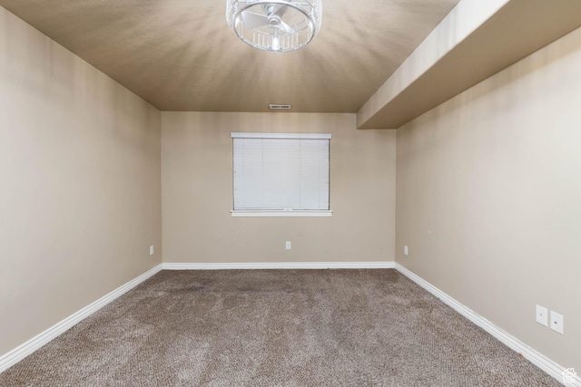 carpeted empty room featuring baseboards and visible vents