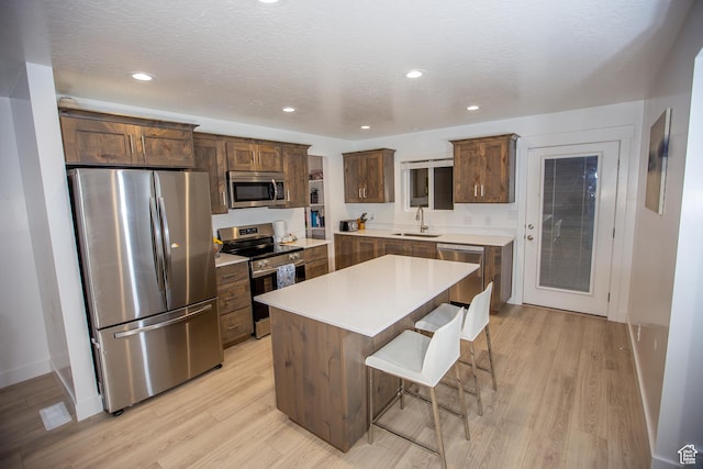 1511 S Sageberry Dr, Santaquin, UT 84655 - kitchen featuring stainless steel appliances, a sink, light wood-style floors, a breakfast bar area, and a center island