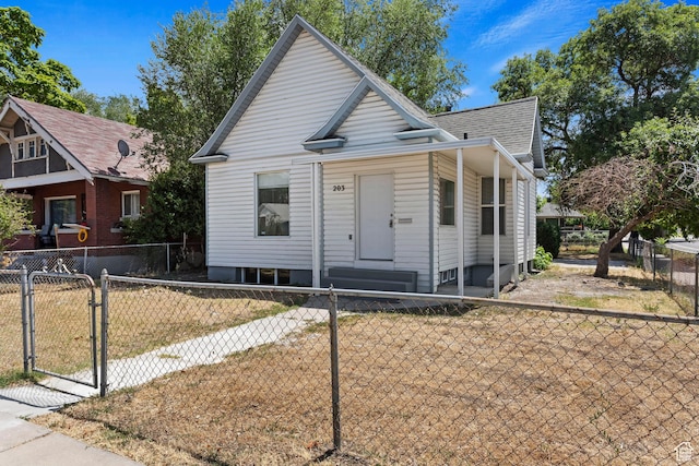 bungalow-style house with a gate, fence private yard, and roof with shingles